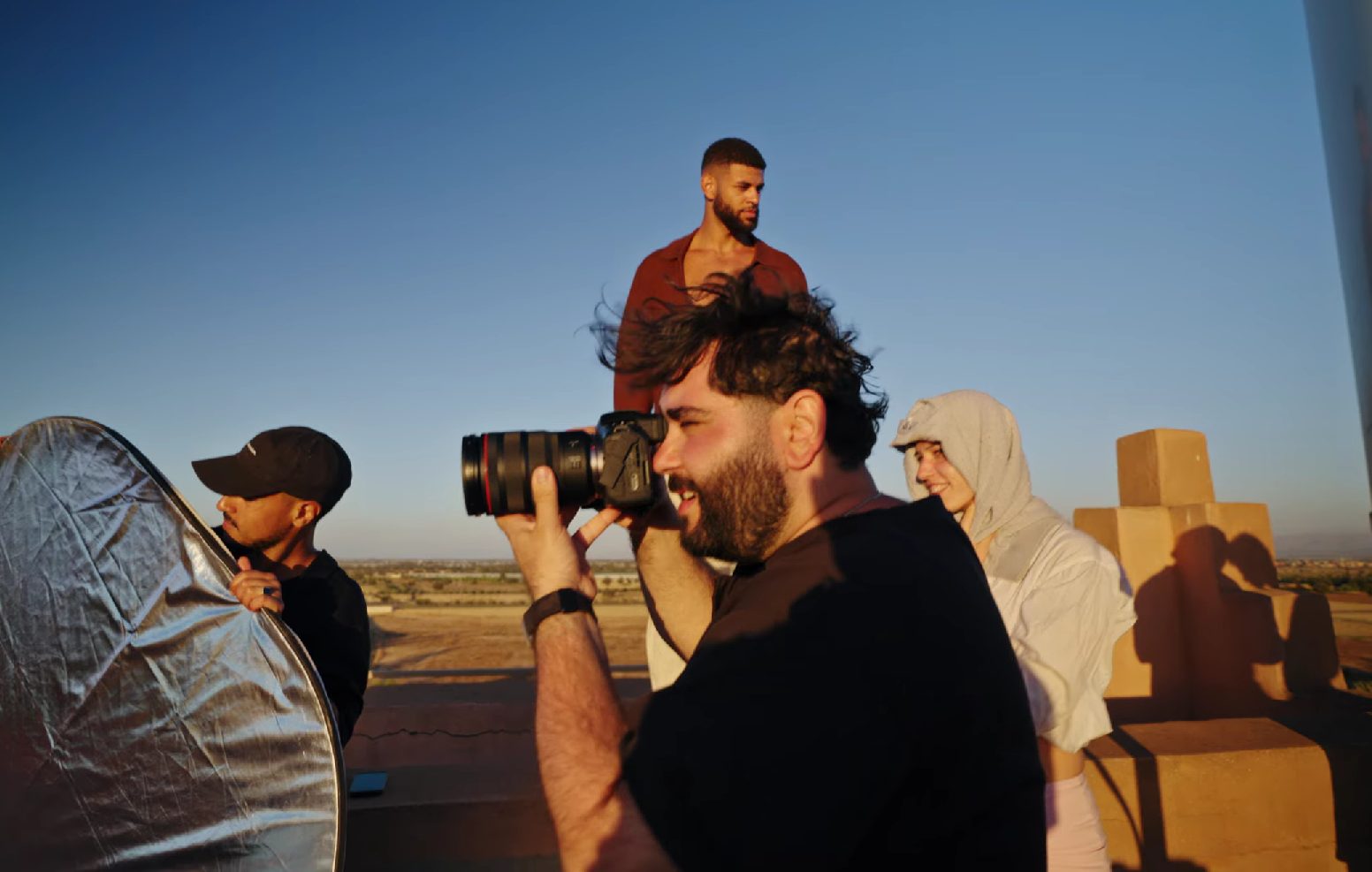 Photographer shooting a creator on location at golden hour